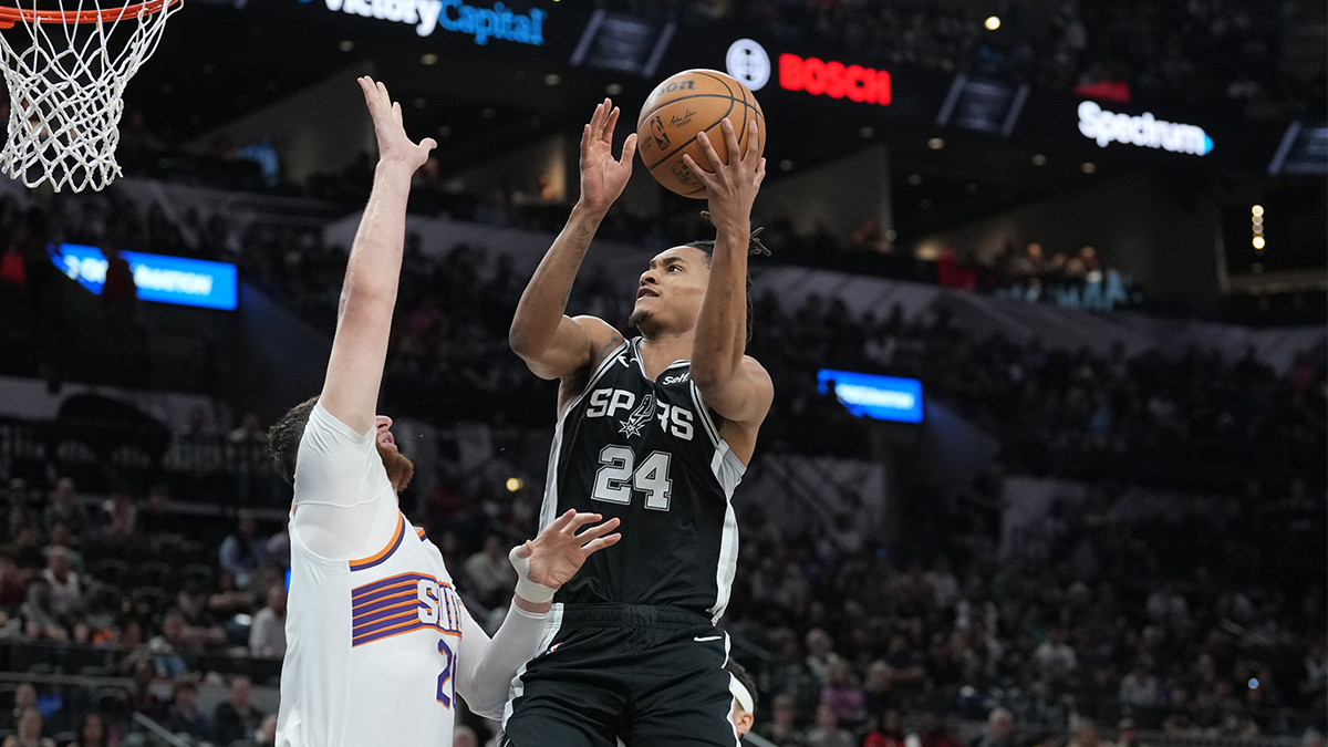 San Antonio Spurs guard Devin Vassell (24) throws over Phoenix Suns center Jusuf Nurkic (20) in the first half at Frost Bank Center.