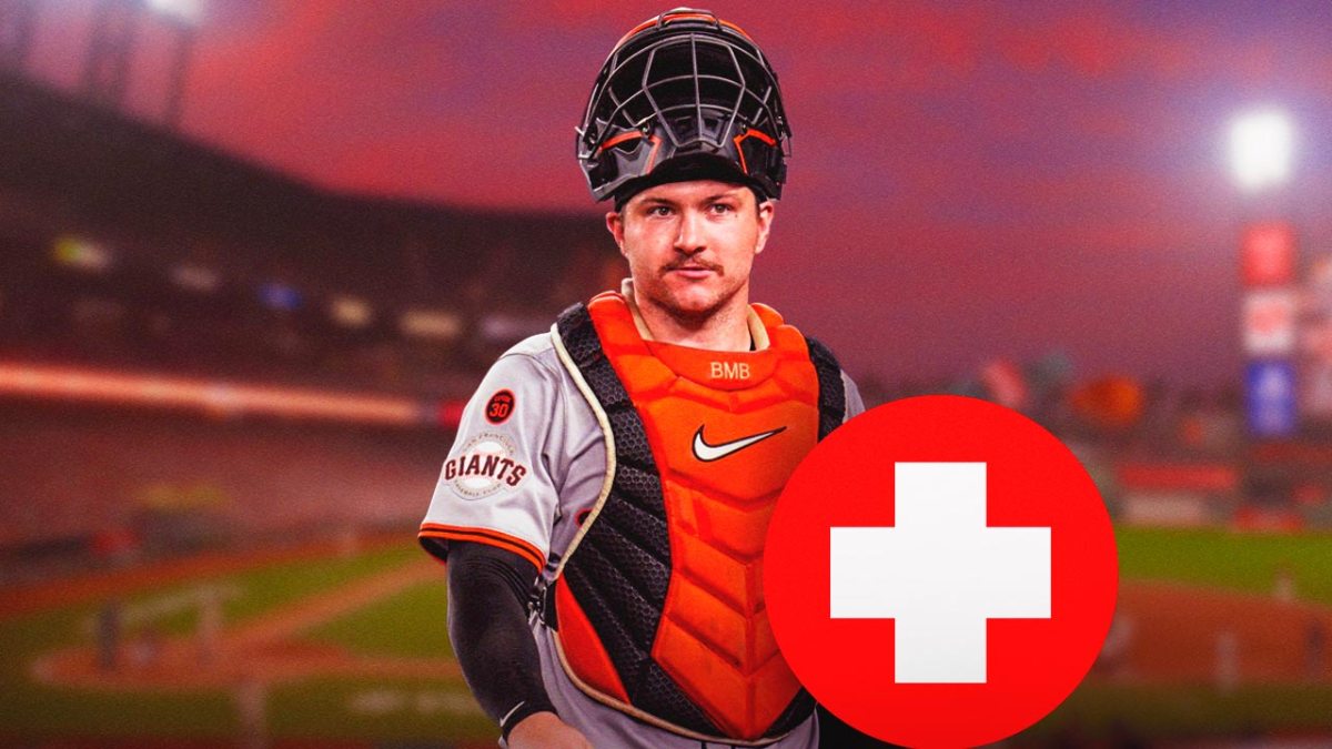 Patrick Bailey in a San Francisco Giants uniform with his catcher's gear on and a red and white first aid symbol as the Giants catcher will move to the injured list with a strain as the latest of the Giants injuries.