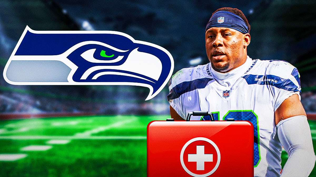 Seahawks pass rusher Uchenna Nwosu limping off a football field next to the Seahawks logo