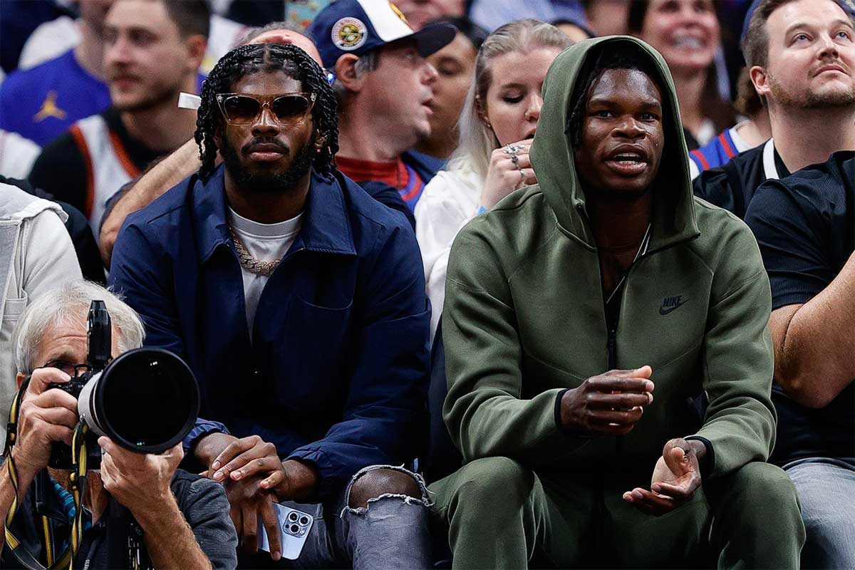 University of Colorado Buffaloes football players Shedeur Sanders (L) and Travis Hunter (R) watch during the third period between the Denver Nuggets and the Los Angeles Lakers at Ball Arena.
