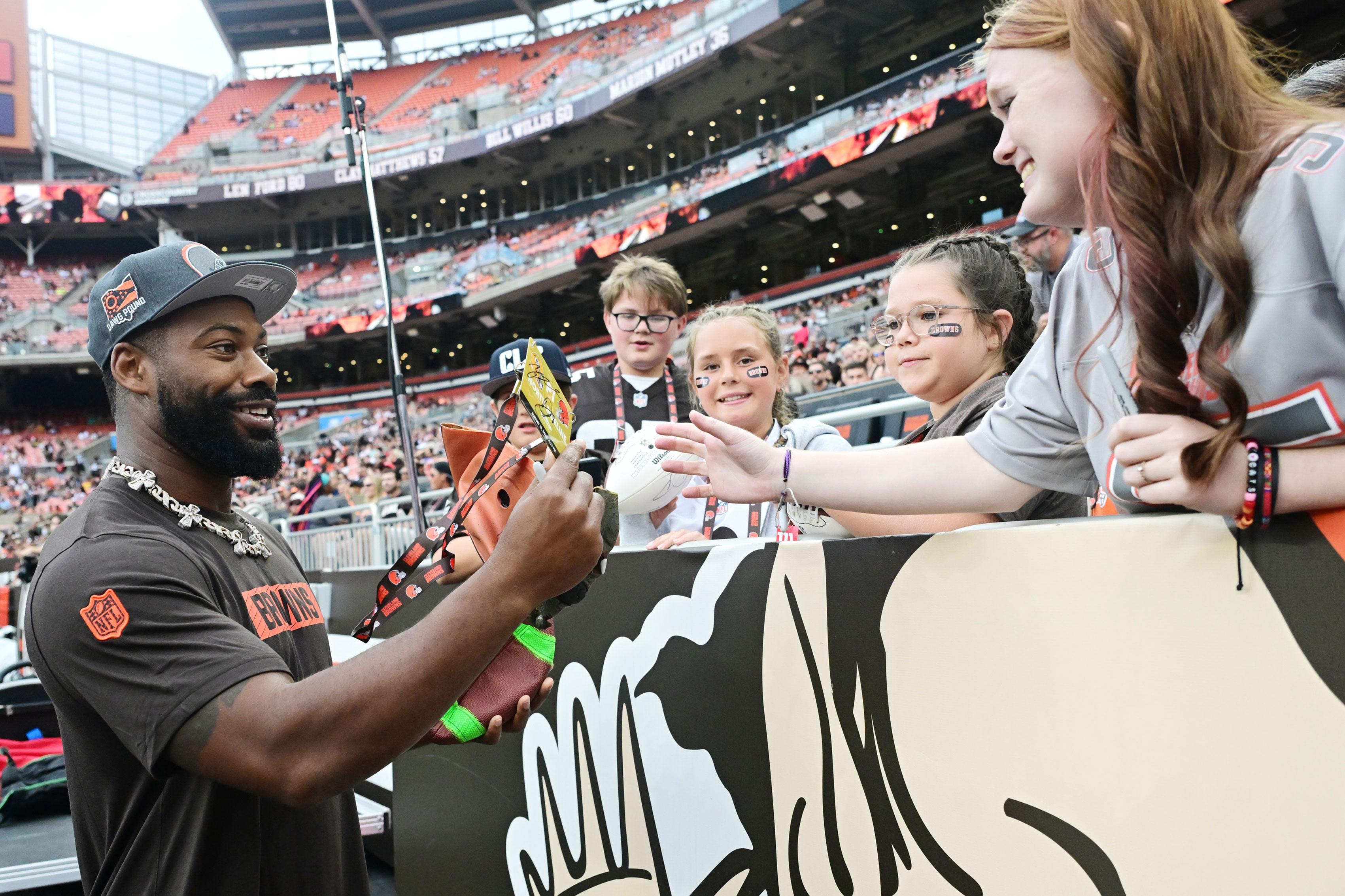 Cleveland Browns defensive end Za'Darius Smith (99) signs autographs for fans during the second half of the game against the Green Bay Packers at Cleveland Browns Stadium. 