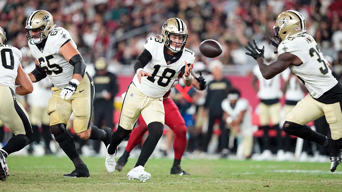 New Orleans Saints quarterback Spencer Rattler (18) tosses the ball to New Orleans Saints running back Jordan Mims (33) against the Arizona Cardinals during the second half at State Farm Stadium.