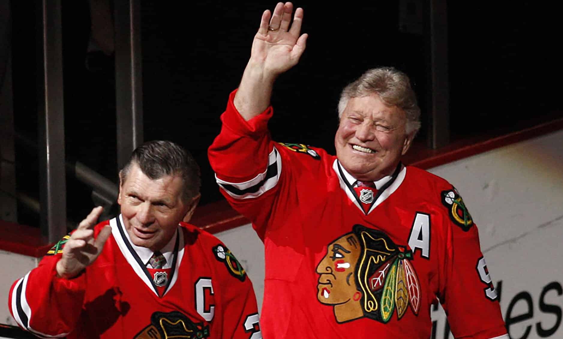 Chicago Blackhawks former players Stan Mikita (21) and Bobby Hull (9) wave to the crowd as they are introduced during a ceremony honoring their careers before the game against the San Jose Sharks at the United Center.