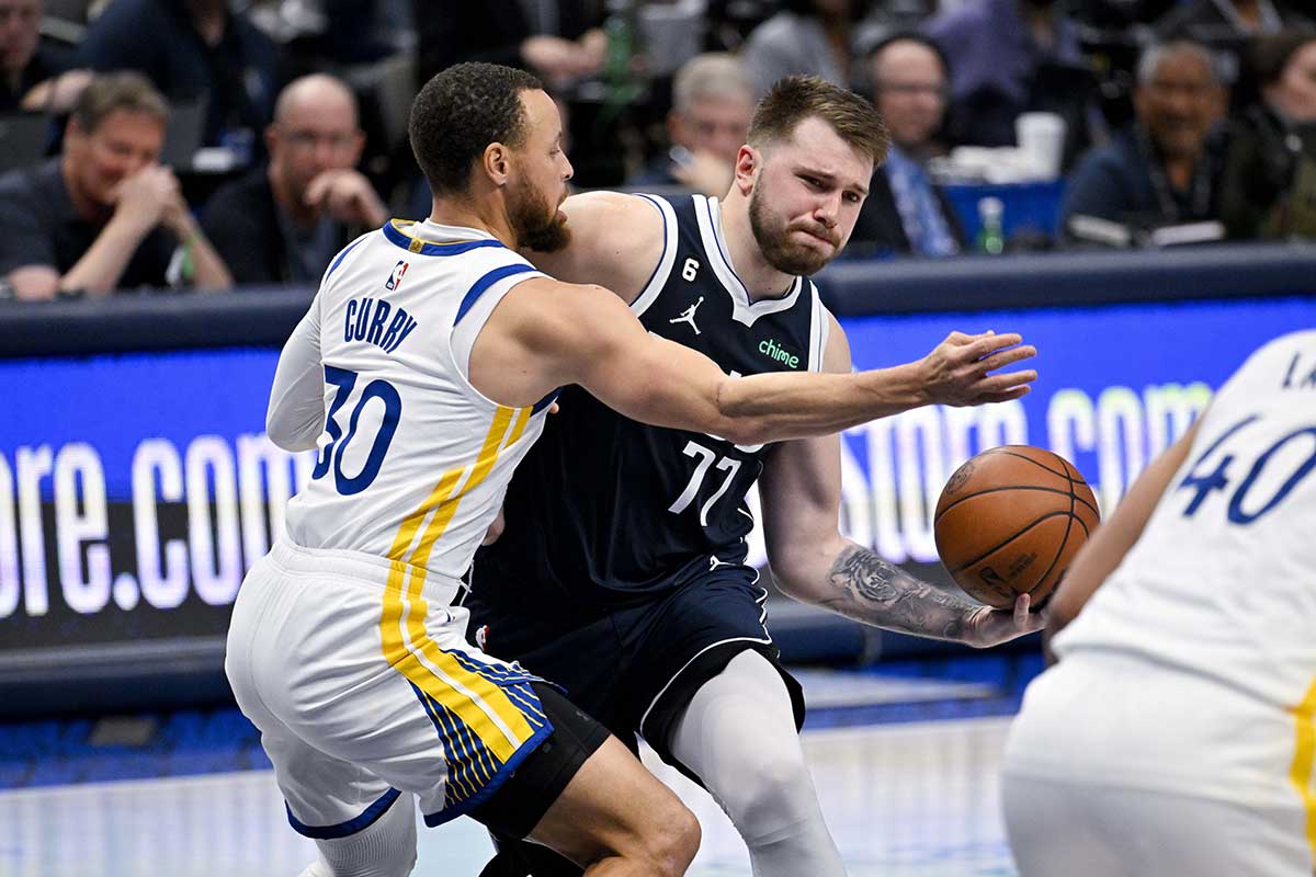 Dallas Mavericks guard Luka Doncic (77) drives to the basket past Golden State Warriors guard Stephen Curry (30) during the second half at the American Airlines Center. 