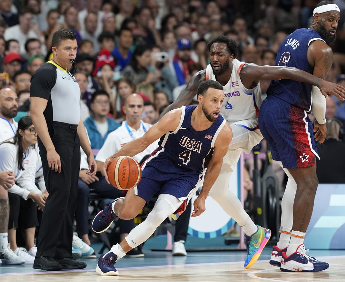 United States shooting guard Stephen Curry (4) dribbles using a pick by guard LeBron James (6) on Puerto Rico shooting guard Davon Reed (9) in the third quarter during the Paris 2024 Olympic Summer Games at Stade Pierre-Mauroy.