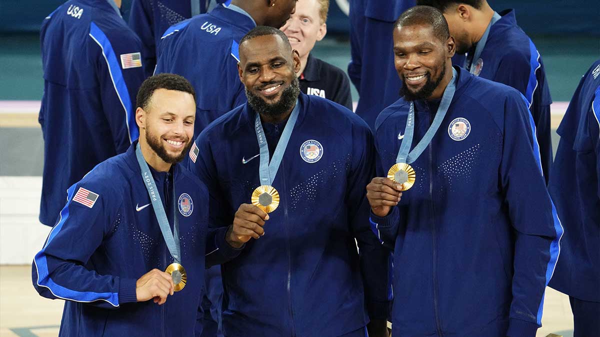 United States shooting guard Stephen Curry (4) and guard LeBron James (6) and guard Kevin Durant (7) celebrate with their gold medals on the podium after defeating France in the men's basketball gold medal game during the Paris 2024 Olympic Summer Games at Accor Arena.
