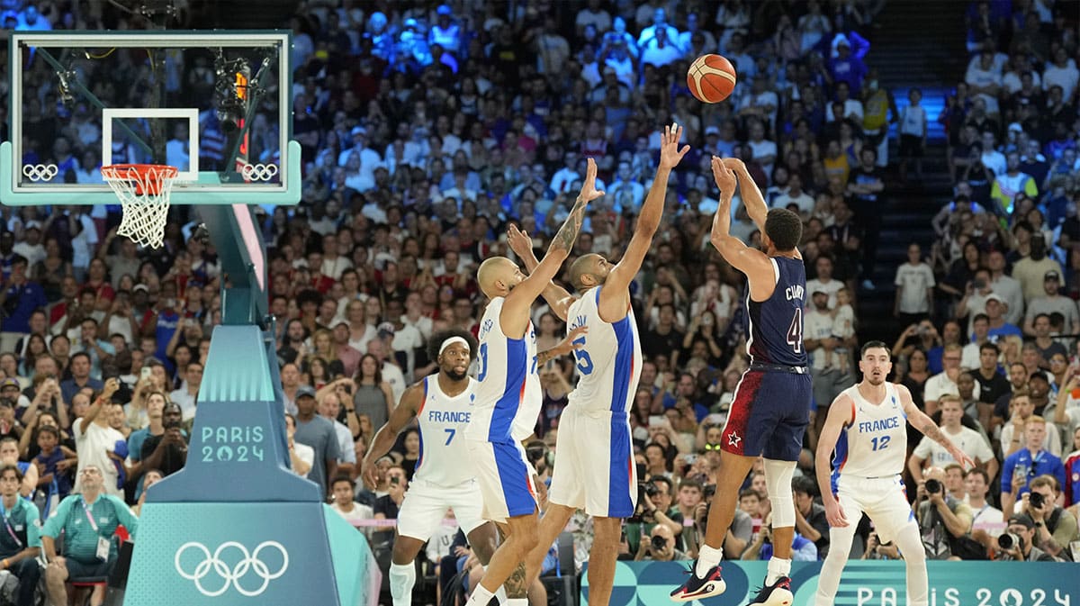 United States shooting guard Stephen Curry (4) shoots against France small forward Nicolas Batum (5) and shooting guard Evan Fournier (10) in the second half against France in the men's basketball gold medal game during the Paris 2024 Olympic Summer Games at Accor Arena.