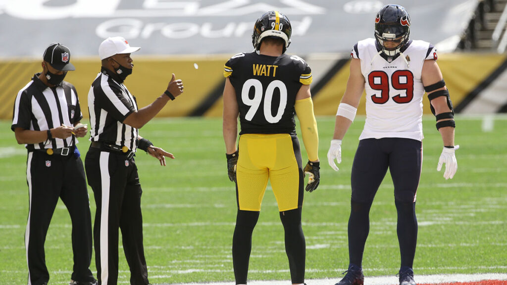 NFL referee Shawn Smith (14) flips the coin as brothers Pittsburgh Steelers outside linebacker T.J. Watt (90) and Houston Texans defensive end J.J. Watt (99) take part before their game against at Heinz Field. The Steelers won 28-21. 
