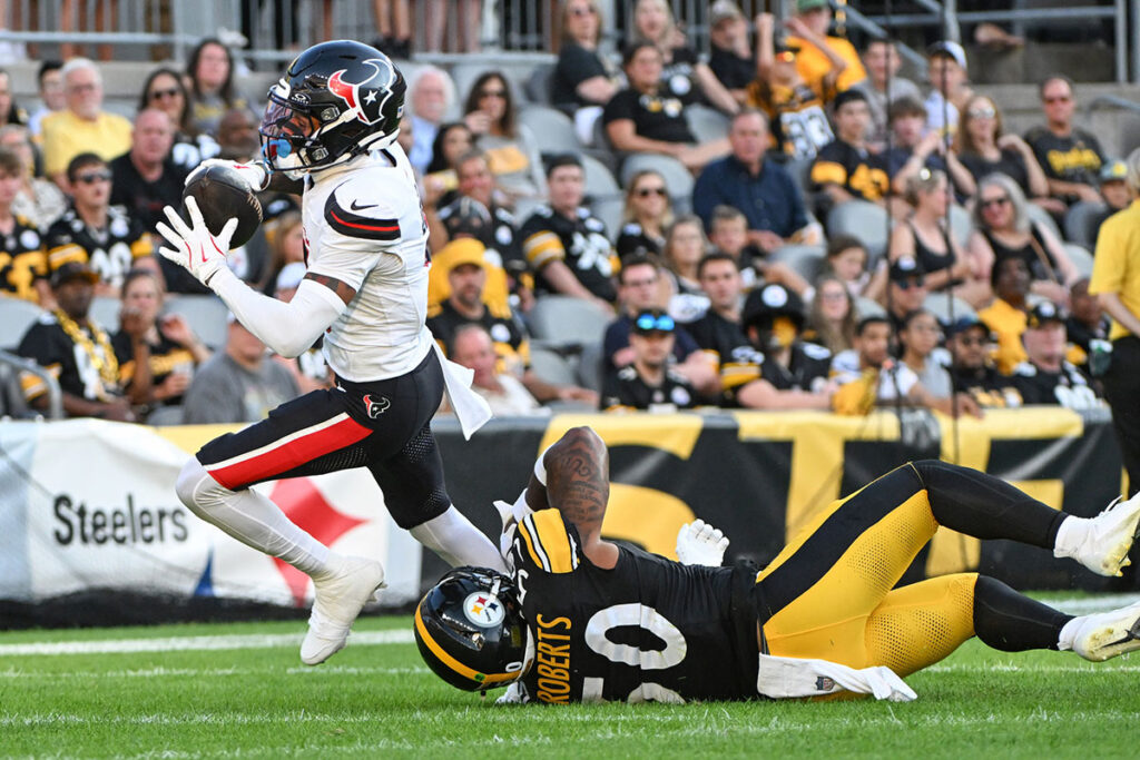 Houston Texans wide receiver Tank Dell (3) eludes Pittsburgh Steelers linebacker Elandon Roberts (50) to score a touchdown during the first quarter at Acrisure Stadium.