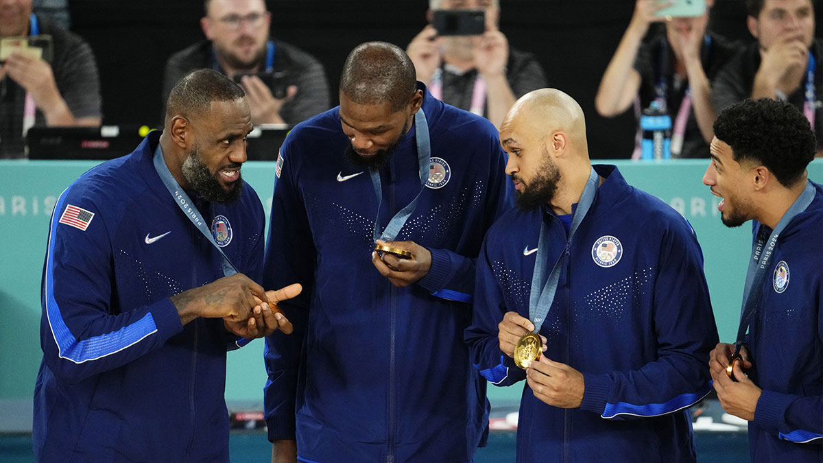 US guards LeBron James (6), Kevin Durant (7) and Derrick White (8) celebrate with the gold medal after defeating France in the men's basketball game during the 2024 Summer Olympics in Paris at the Accor Arena.