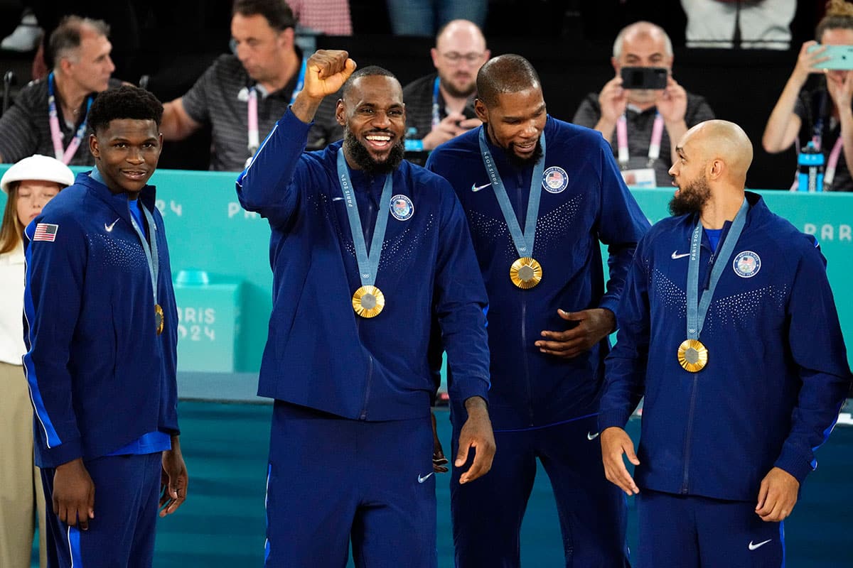 Aug 10, 2024; Paris, France; United States guard Anthony Edwards (5) and guard LeBron James (6) and guard Kevin Durant (7) and guard Derrick White (8) celebrate with their gold medals on the podium after defeating France in the men's basketball gold medal game during the Paris 2024 Olympic Summer Games at Accor Arena.