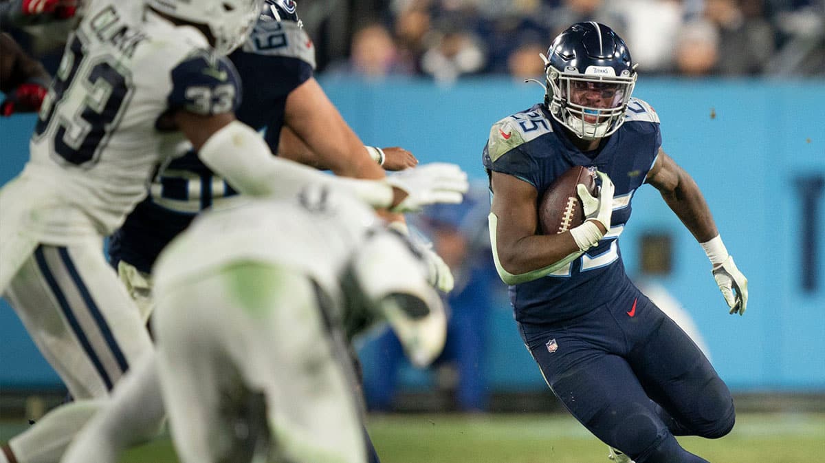 Tennessee Titans running back Hassan Haskins (25) races up the field past Dallas Cowboys defenders during the third quarter at Nissan Stadium.