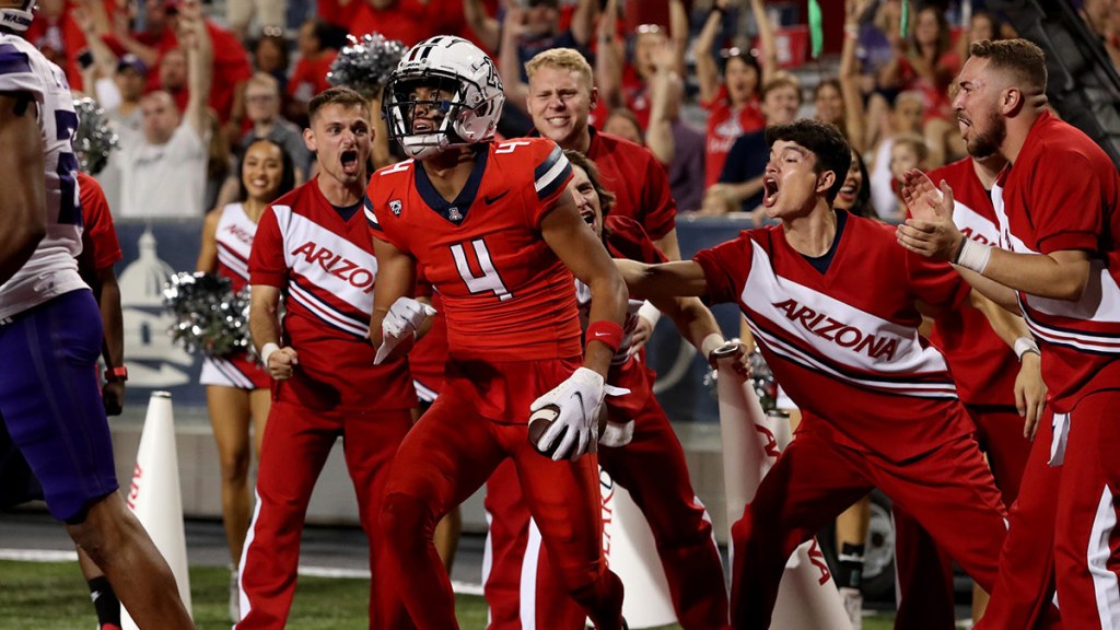 Arizona Wildcats wide receiver Tetairoa McMillan (4) celebrates a touchdown agaisnt the Washington Huskies with the cheer leaders in the second half at Arizona Stadium.