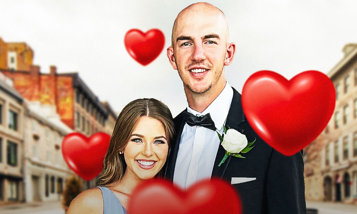 Oklahoma City Thunder PG Alex Caruso with his fiance Haleigh Broucher with a big heart behind them and an engagement ring on her finger. With cupids and hearts around them