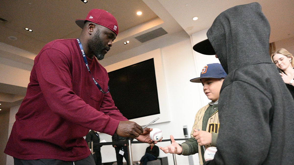 Former MLB player Tony Gwynn Jr. (left) signs autographs for fans at Manchester Grand Hyatt.