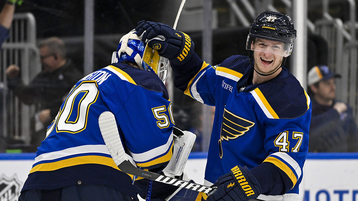 St. Louis Blues defenseman Torey Krug (47) celebrates with goaltender Jordan Binnington (50) after they both assisted on an empty net goal by left wing Pavel Buchnevich (not pictured) against the Calgary Flames during the third period at Enterprise Center. 