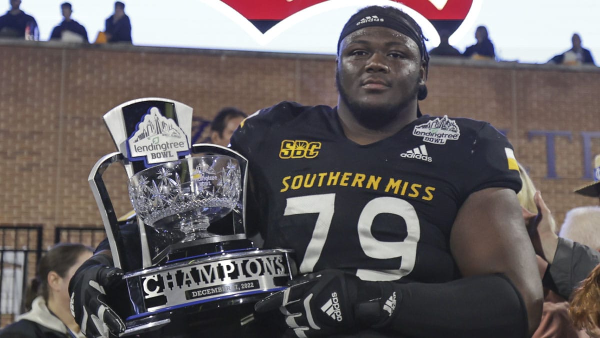 Southern Miss Golden Eagles offensive lineman Tykeem Doss (79) poses with the Lending Tree Bowl Championship Trophy after defeating the Rice Owls in the Lending Tree Bowl at Hancock Whitney Stadium.