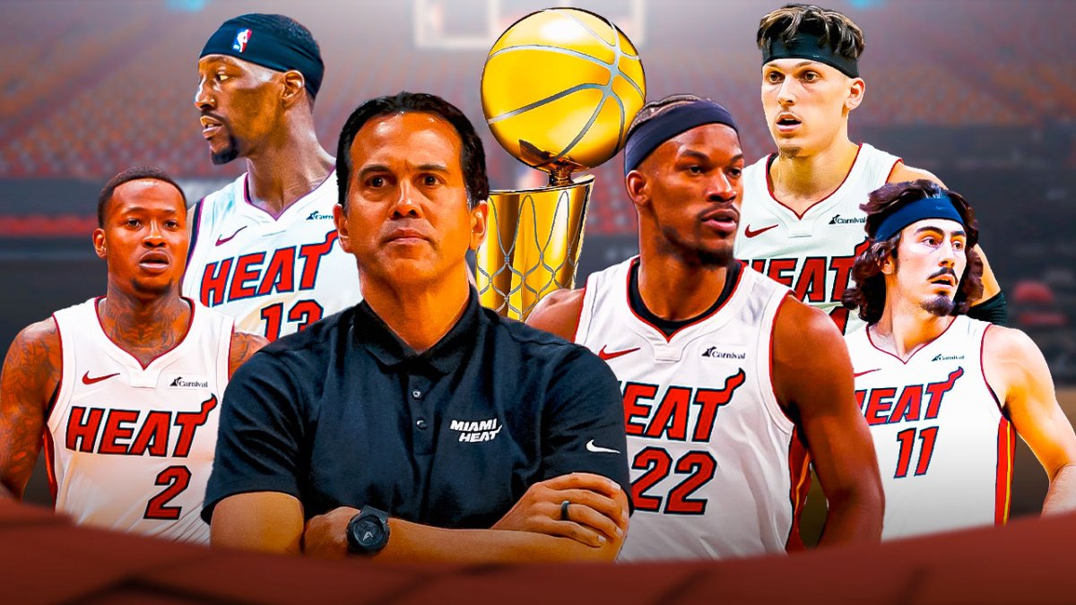 Tyler Herro in Miami Heat uniform with Erik Spoelstra, Bam Adebayo, Jimmy Butler, Terry Rozier and Jaime Jaquez. Larry O'Brien trophy in the background.