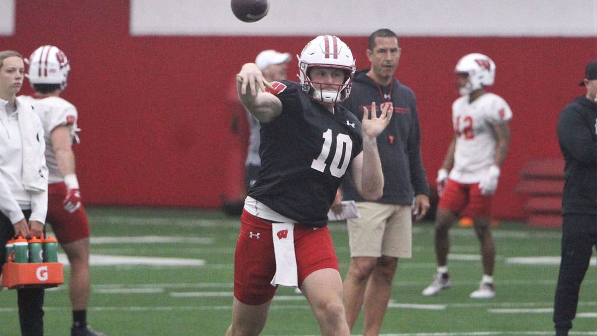 Wisconsin quarterback Tyler Van Dyke throws a pass as coach Luke Fickell watches during spring practice at the McClain Center in Madison, Wisconsin on Tuesday April 2, 2024.