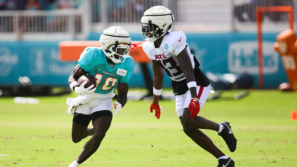 Miami Dolphins wide receiver Tyreek Hill (10) runs with the football against Atlanta Falcons cornerback Anthony Johnson (43) during a joint practice at Baptist Health Training Complex.