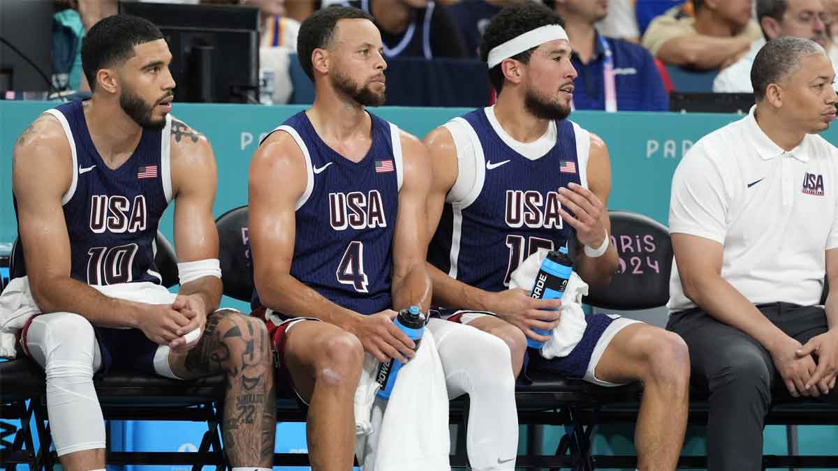 Aug 3, 2024; Villeneuve-d'Ascq, France; United States small forward Jayson Tatum (10), shooting guard Stephen Curry (4), guard Devin Booker (15) and assistant coach Tyronn Lue on the bench in the third quarter against Puerto Rico during the Paris 2024 Olympic Summer Games at Stade Pierre-Mauroy. Mandatory Credit: John David Mercer-USA TODAY Sports