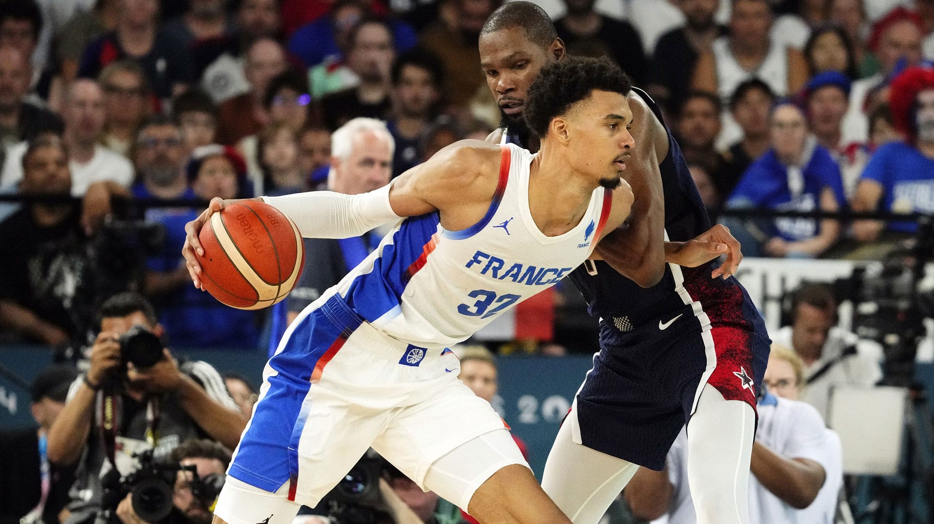 France power forward Victor Wembanyama (32) controls the ball against United States guard Kevin Durant (7) in the second half in the men's basketball gold medal game during the Paris 2024 Olympic Summer Games at Accor Arena.