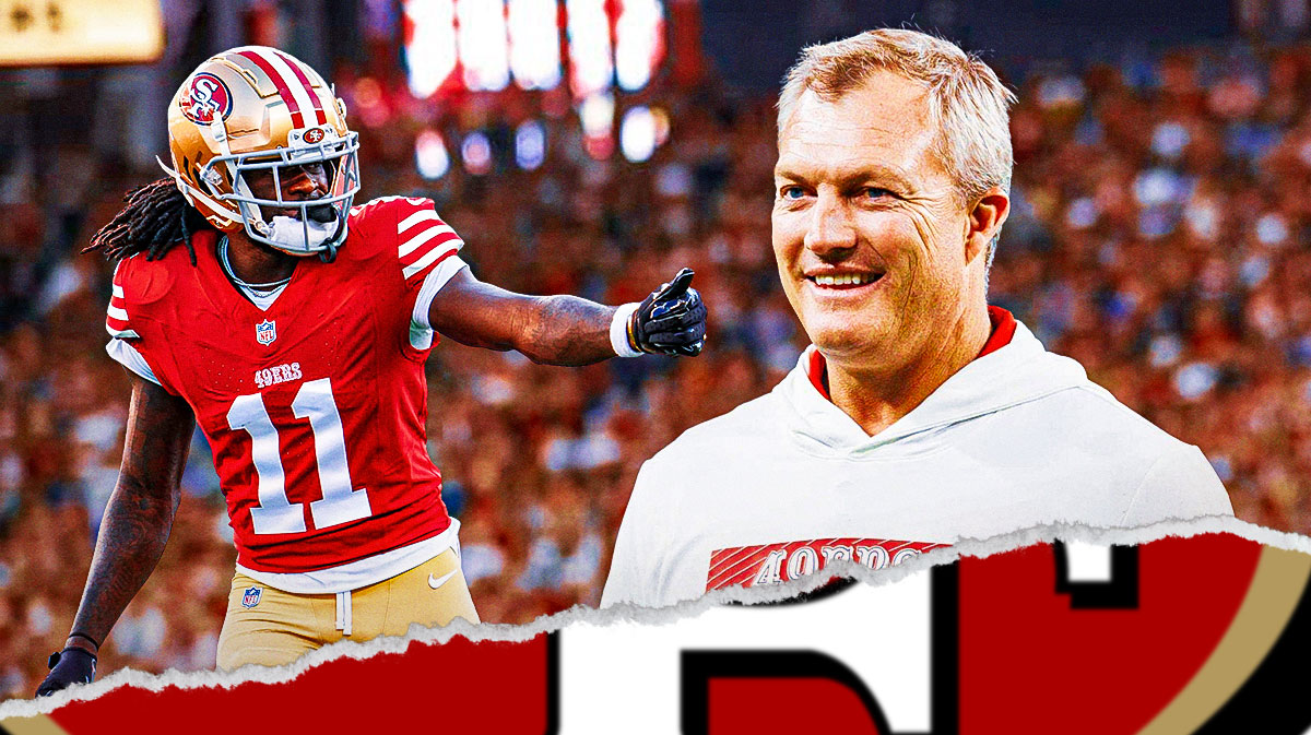 John Lynch stands next to Brandon Aiyuk