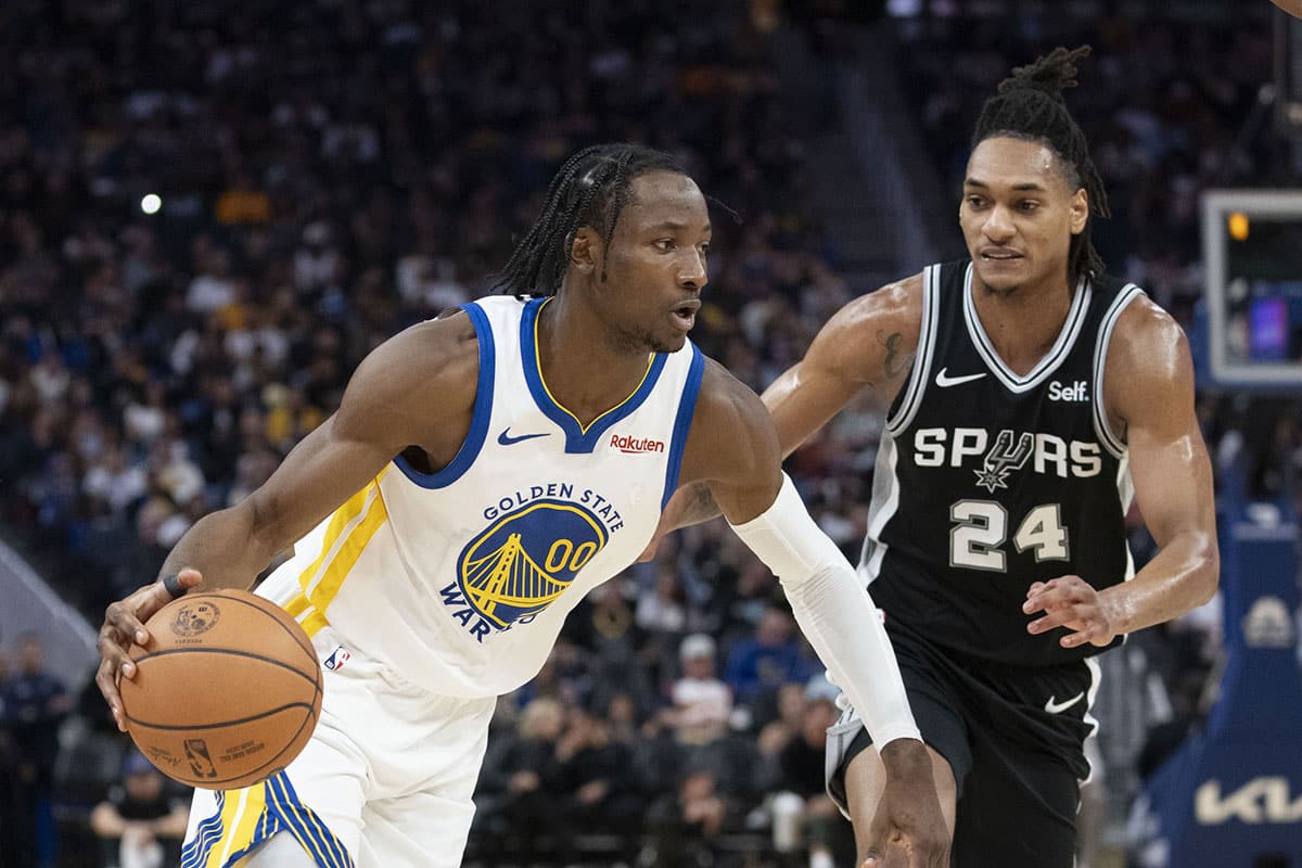 Golden State Warriors forward Jonathan Kuminga (00) dribbles the basketball against San Antonio Spurs guard Devin Vassell (24) during the third quarter at Chase Center