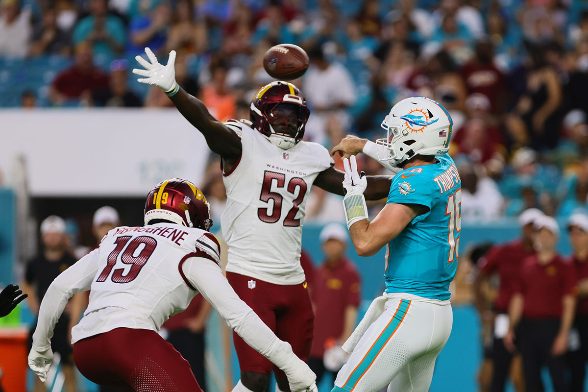 Miami Dolphins quarterback Skylar Thompson (19) throws the football as Washington Commanders linebacker Jamin Davis (52) defends during the second quarter of a preseason game at Hard Rock Stadium.