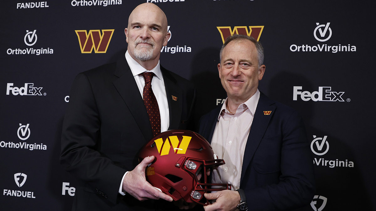 Washington Commanders head coach Dan Quinn (L) poses for a picture with Commanders managing partner Josh Harris (R) at Quinn's introductory press conference at Commanders Park.