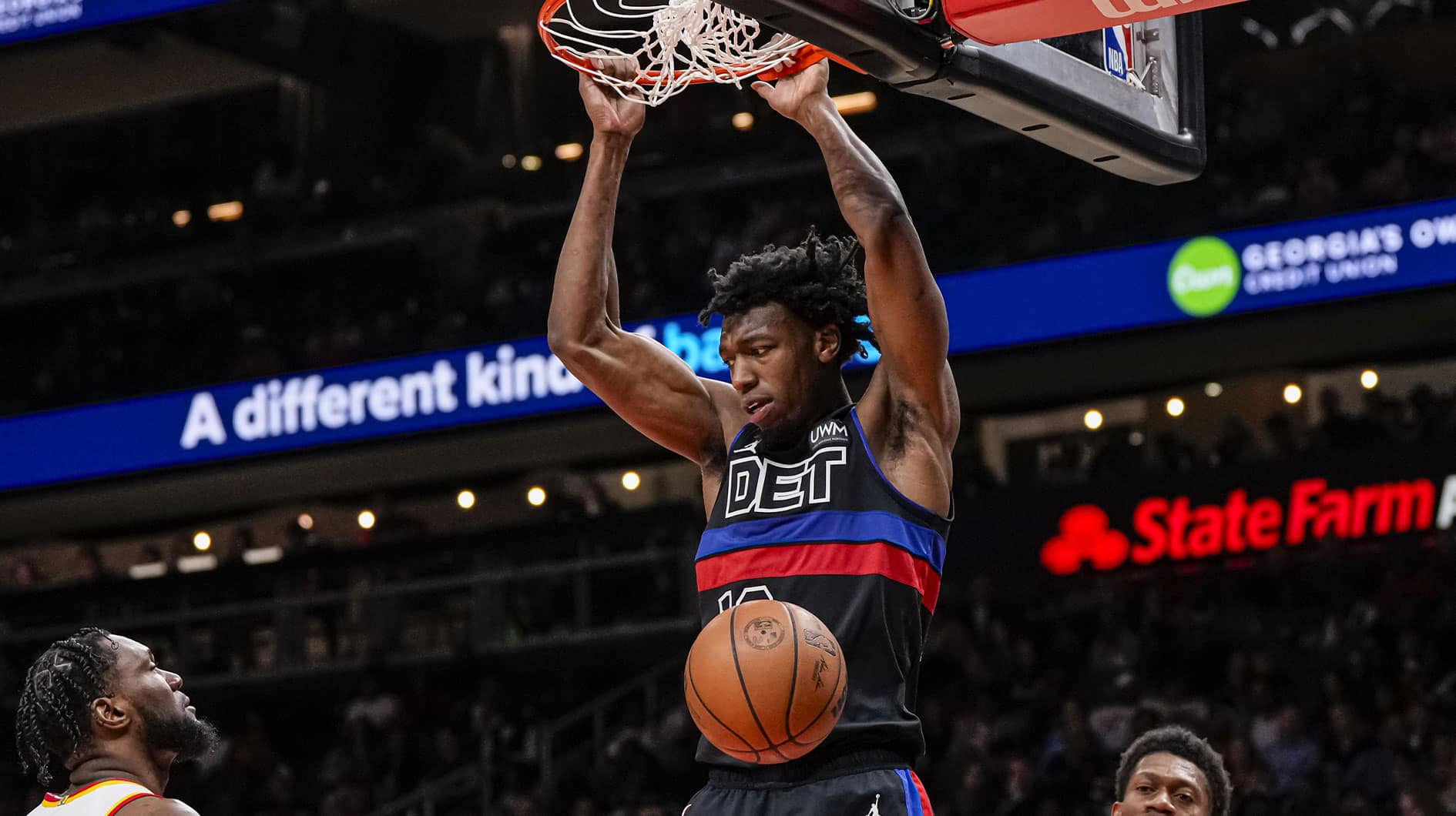  Detroit Pistons center James Wiseman (13) dunks between Atlanta Hawks forwards Bruno Fernando (24) and De'Andre Hunter (12) during the second half at State Farm Arena.