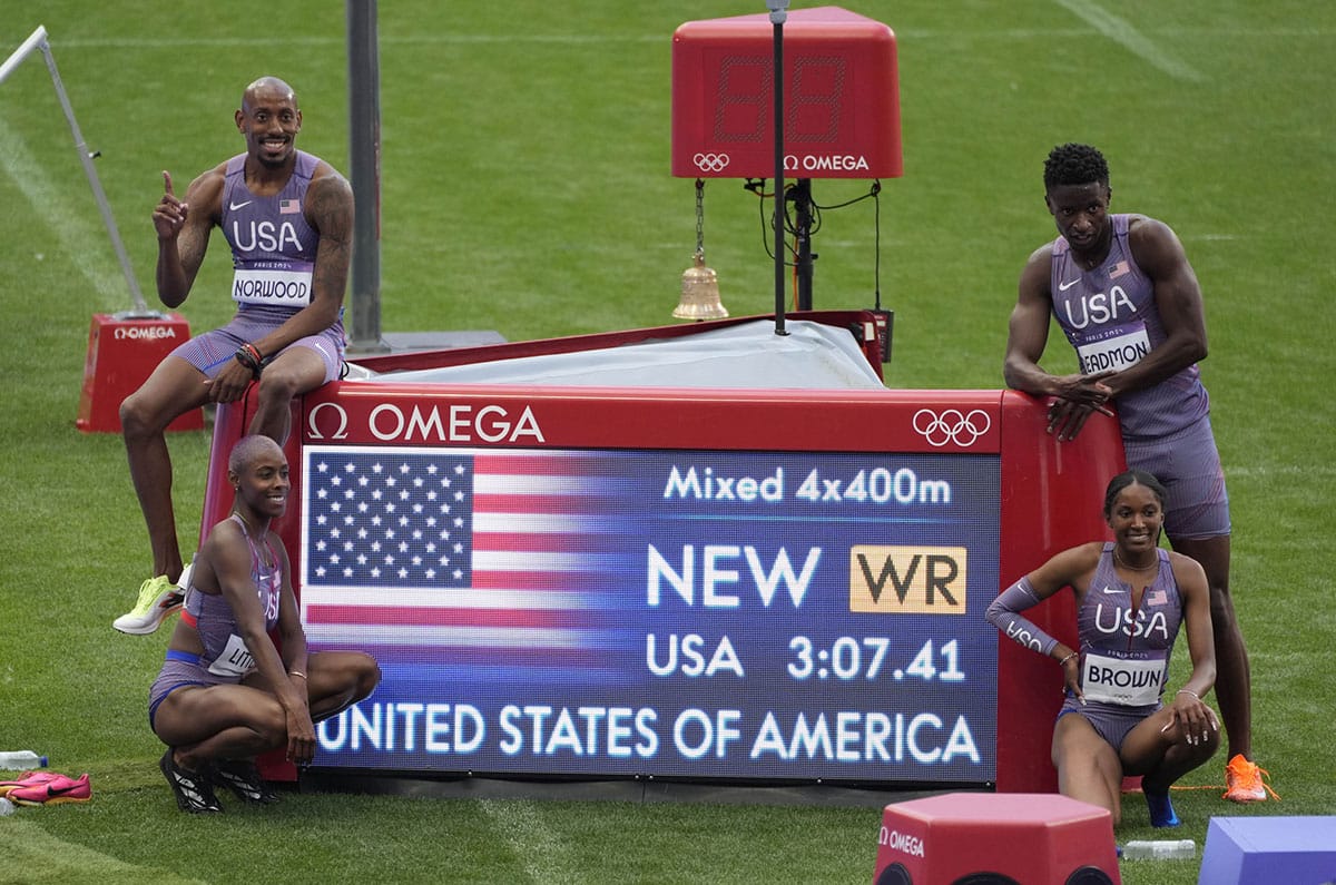 Vernon Norwood (USA), Shamier Little (USA), Bryce Deadmon (USA) and Kaylyn Brown (USA) pose with their world record time after the 4x400m relay mixed round 1 during the Paris 2024 Olympic Summer Games at Stade de France. 