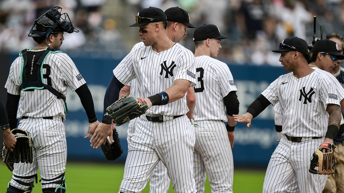 New York Yankees outfielder Aaron Judge (99) slaps hands with teammates after defeating the Cleveland Guardians at Yankee Stadium.