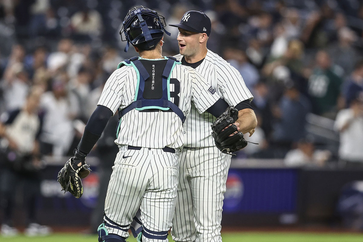 New York Yankees relief pitcher Tim Mayza (58) and catcher Austin Wells (28) celebrate after defeating the Cleveland Guardians 8-1 at Yankee Stadium.