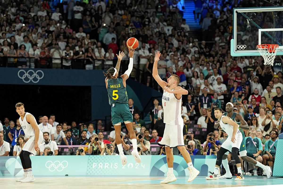  Australia guard Patty Mills (5) shoots the game tying shot against Serbia power forward Nikola Jokic (15) with second left during the second half in men’s basketball quarterfinals during the Paris 2024 Olympic Summer Games at Accor Arena.