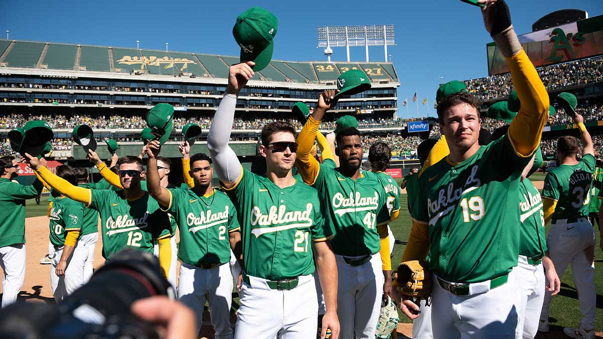 Oakland Athletics players tip their caps to the crowd after the game against the Texas Rangers at Oakland-Alameda County Coliseum.