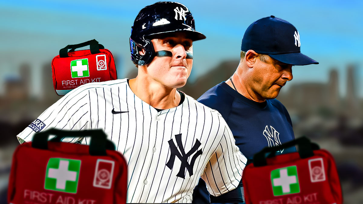 New York Yankees first baseman Anthony Rizzo with first-aid kits around them with Yankees manager Aaron Boone next to him.