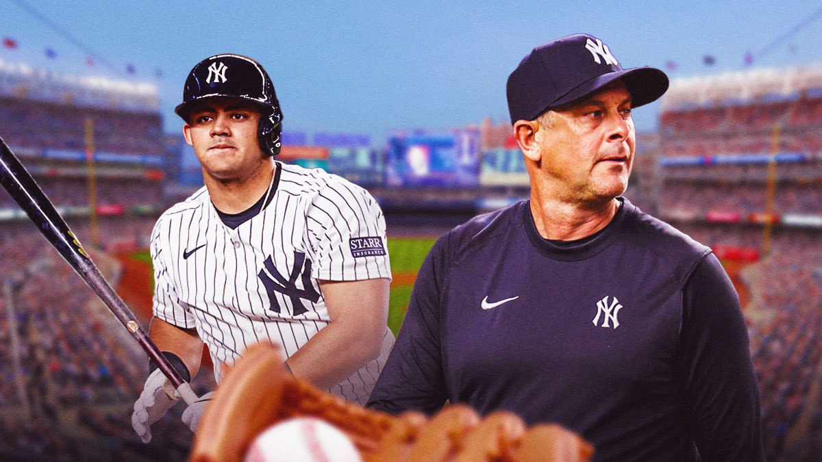 Aaron Boone and Jasson Dominguez in a New York Yankees uniform as Boone is holding top prospect Dominguez out of the game against the Royals in favor of alex verdugo and dominguez is benched for Wednesday.