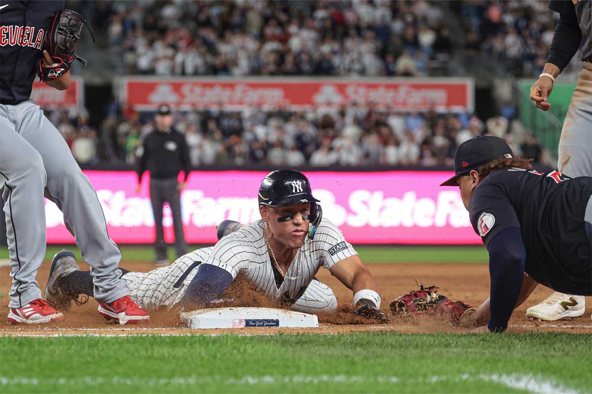 New York Yankees center fielder Aaron Judge (99) slides safely back to first base as Cleveland Guardians first baseman Josh Naylor (22) tags during the tenth inning at Yankee Stadium.