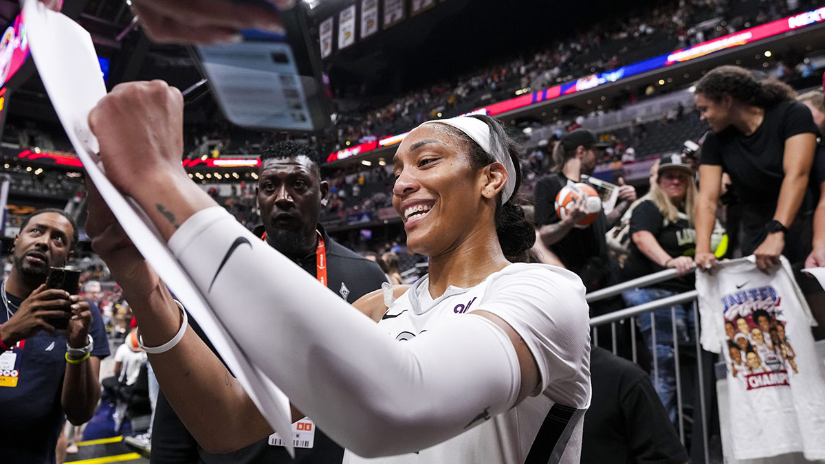 Las Vegas Aces center A'ja Wilson (22) signs a poster Friday, Sept. 13, 2024, during a game between the Indiana Fever and the Las Vegas Aces on Friday, Sept. 13, 2024, at Gainbridge Fieldhouse in Indianapolis. The Aces defeated the Fever, 78-74.