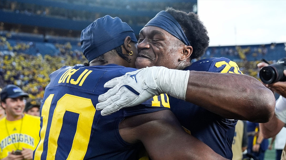 Michigan quarterback Alex Orji (10), left, hugs running back Kalel Mullings (20) after 27-24 win over USC at Michigan Stadium
