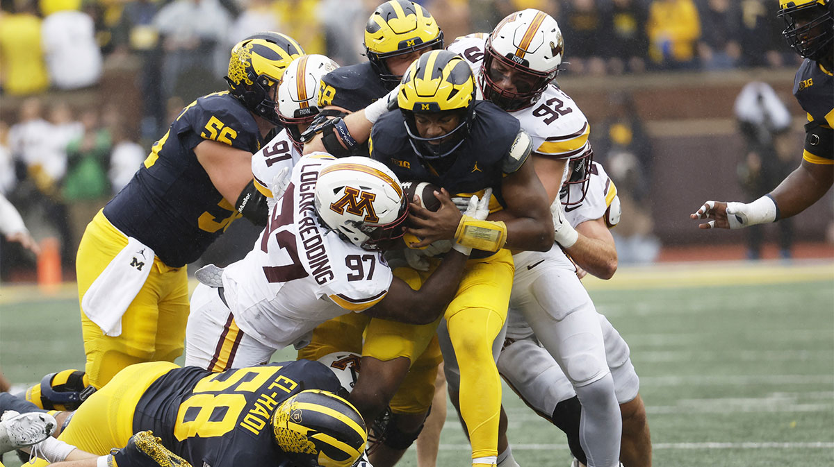 Michigan Wolverines quarterback Alex Orji (10) is tackled by Minnesota Golden Gophers defensive lineman Jalen Logan-Redding (97) in the first half at Michigan Stadium.