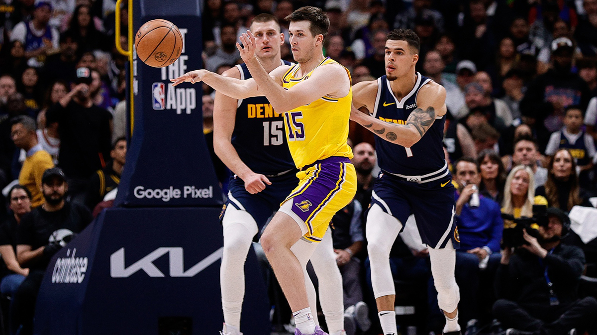 Los Angeles Lakers guard Austin Reaves (15) passes the ball as Denver Nuggets center Nikola Jokic (15) and forward Michael Porter Jr. (1) defend in the third quarter during game five of the first round for the 2024 NBA playoffs at Ball Arena.