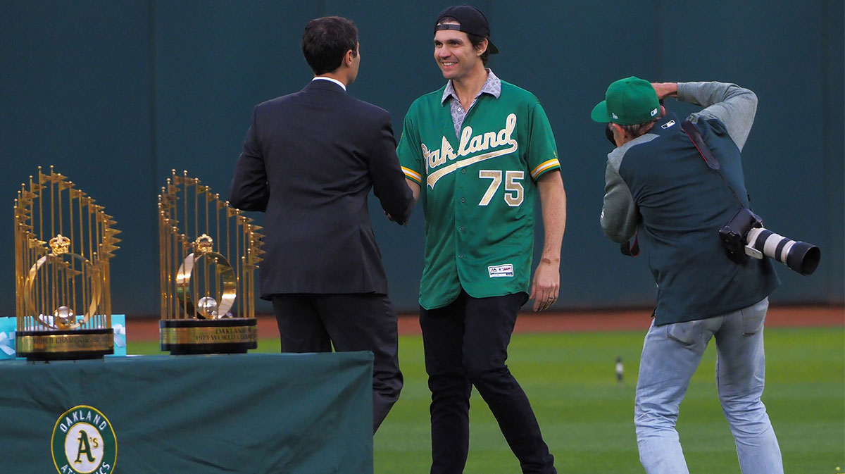 Oakland Athletics president Dave Kaval shakes hands with former player Barry Zito (middle) during a presentation to recognize the 50th anniversary team at Oakland Coliseum.