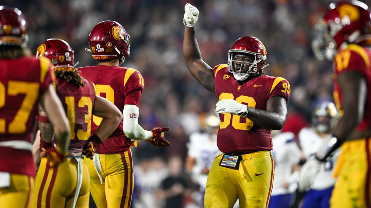 USC Trojans defensive lineman Bear Alexander (90) celebrates with linebacker Eric Gentry (18) and other teammates against the Washington Huskies during the fourth quarter at United Airlines Field at Los Angeles Memorial Coliseum.