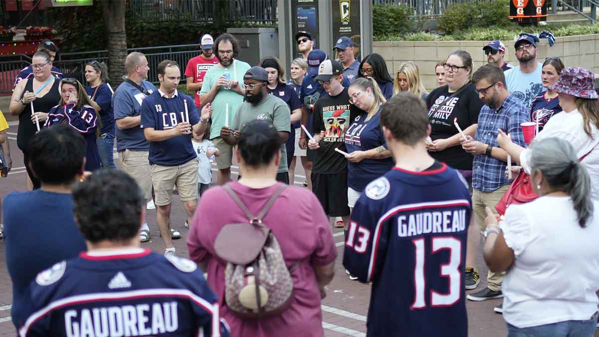 Mourners hold a candlelight vigil outside Nationwide Arena beside a makeshift memorial for Columbus Blue Jackets forward Johnny Gaudreau. Gaudreau and his brother, Matthew, were killed in a bicycle accident the night before.