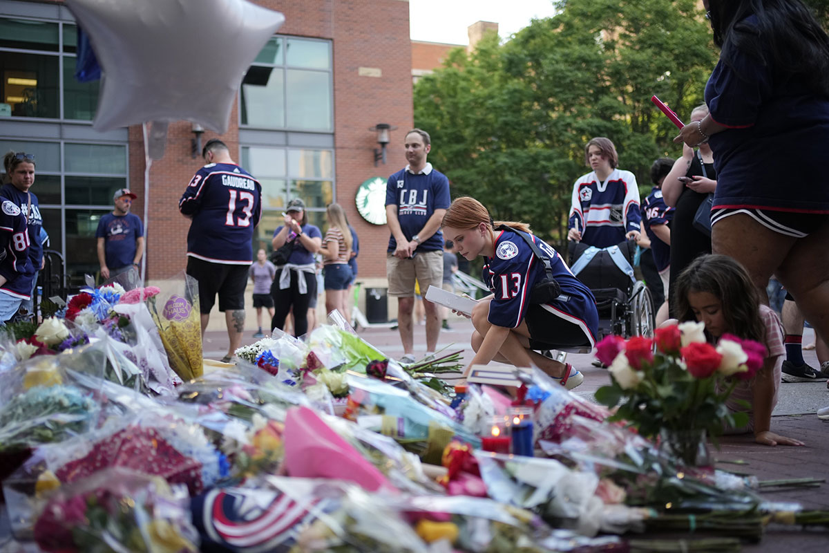 Mourners leave notes, flowers and candles outside Nationwide Arena at a makeshift memorial for Columbus Blue Jackets forward Johnny Gaudreau. Gaudreau and his brother, Matthew, were killed in a bicycle accident the night before.