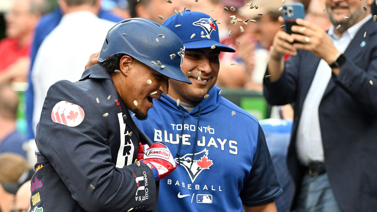 Toronto Blue Jays second baseman Santiago Espinal (5) is greeted by hitting coach Guillermo Martinez (18) after hitting a home run against the Chicago White Sox in the first inning at Rogers Centre