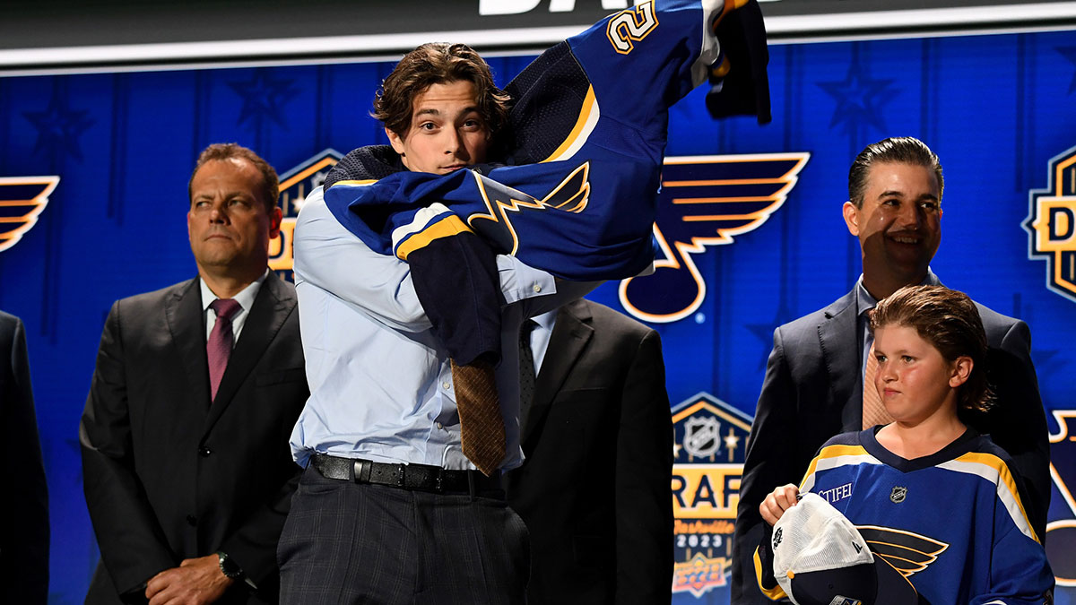 St. Louis Blues draft pick Dalibor Dvorsky puts on his sweater after being selected with the tenth pick in round one of the 2023 NHL Draft at Bridgestone Arena.