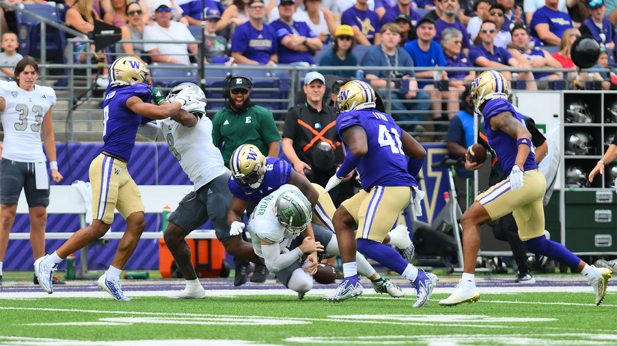 Washington Huskies linebacker Bryun Parham (6) forces a fumble by Eastern Michigan Eagles quarterback Cole Snyder (15) during the first half at Alaska Airlines Field at Husky Stadium.